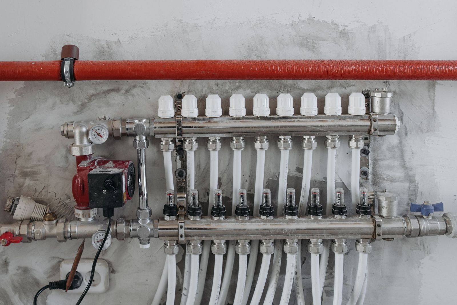 Copper heating pipework and valves run neatly through a plant cupboard